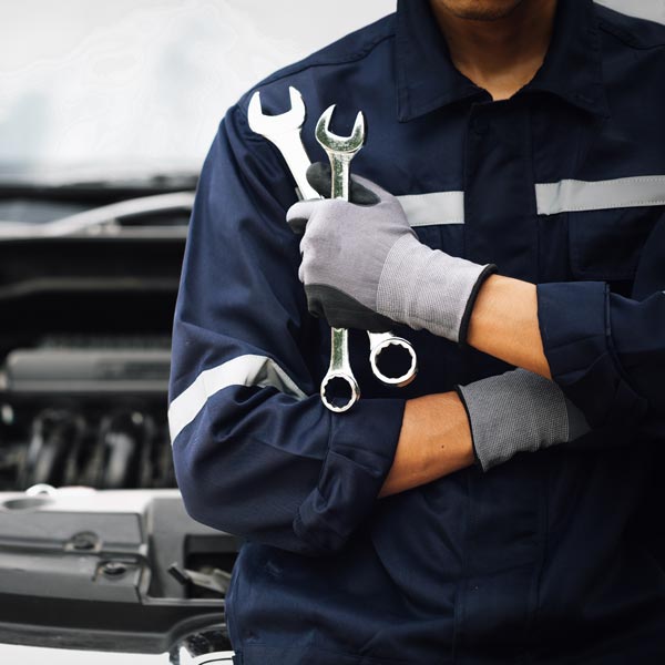 mechanic holding wrenches